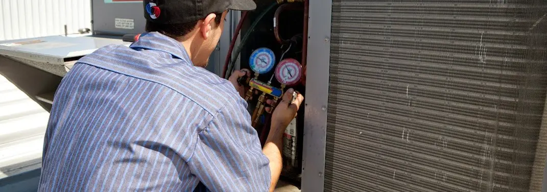 HVAC technician servicing a condenser unit in Brandywine
